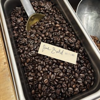 A close-up view of the Joe Bold roasted coffee blend showing its dark and oily nature